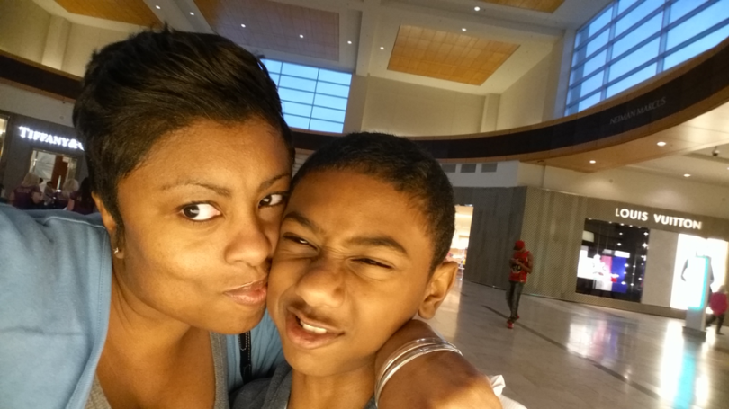 Carol Sankar taking a selfie with her son in a mall.