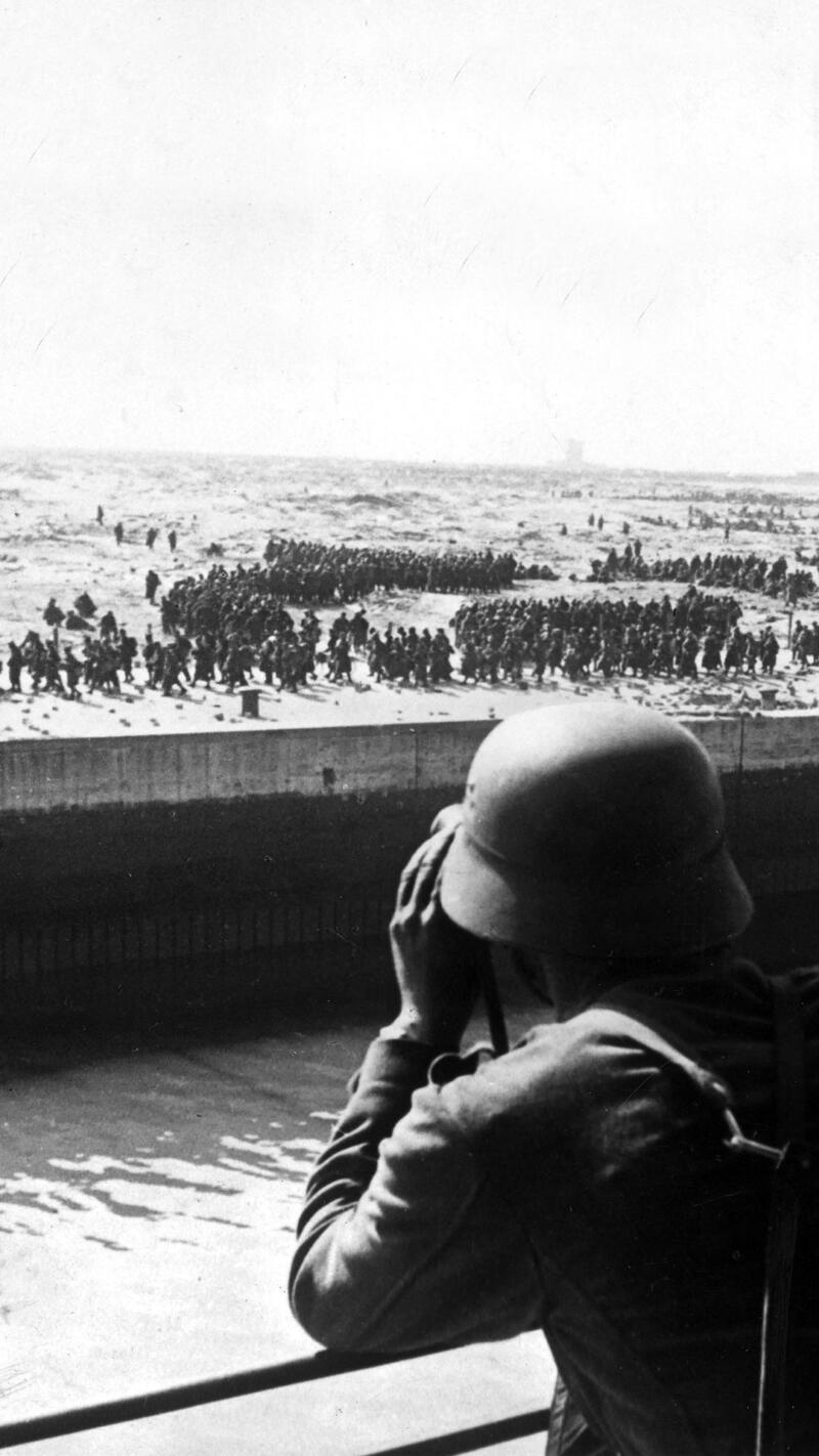 A German soldier looking out at Allied Forces trying to evacuate