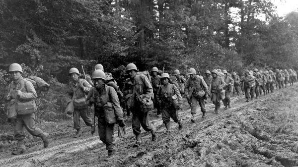 Japanese-American infantrymen of the 442nd Combat Team hike up a muddy French road to their new bivouac area, October 14, 1944. (Credit: HUM Images/Universal Images Group via Getty Images)