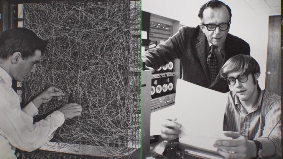 a black-and-white photo of J.C.R. Licklider at the desk of another man working at a computer