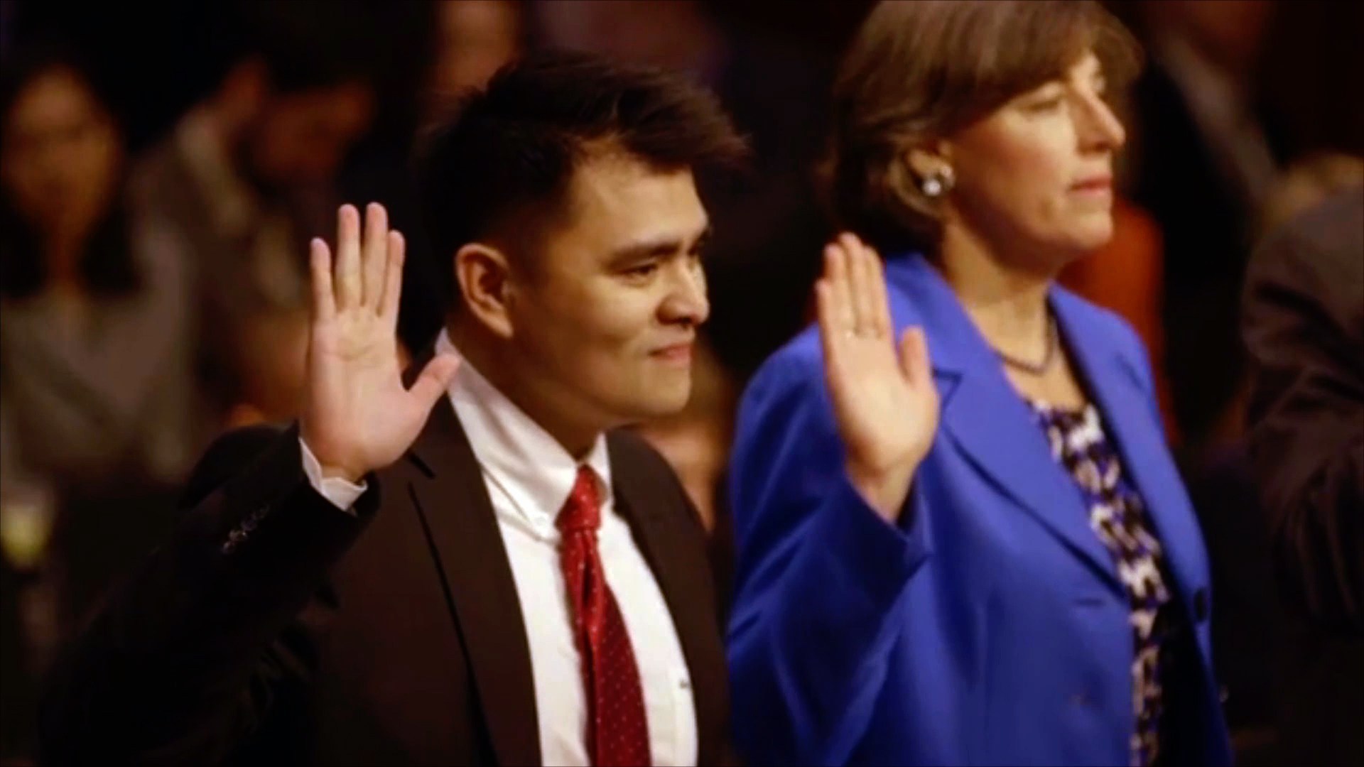 a photo of jose antonio vargas with his right hand raised, ready to speak
