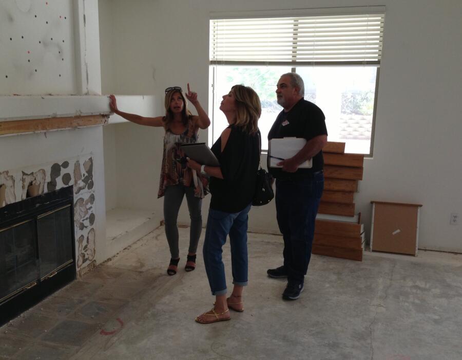 Amie walks through a house with tile installers to discuss quantity and measurements.
