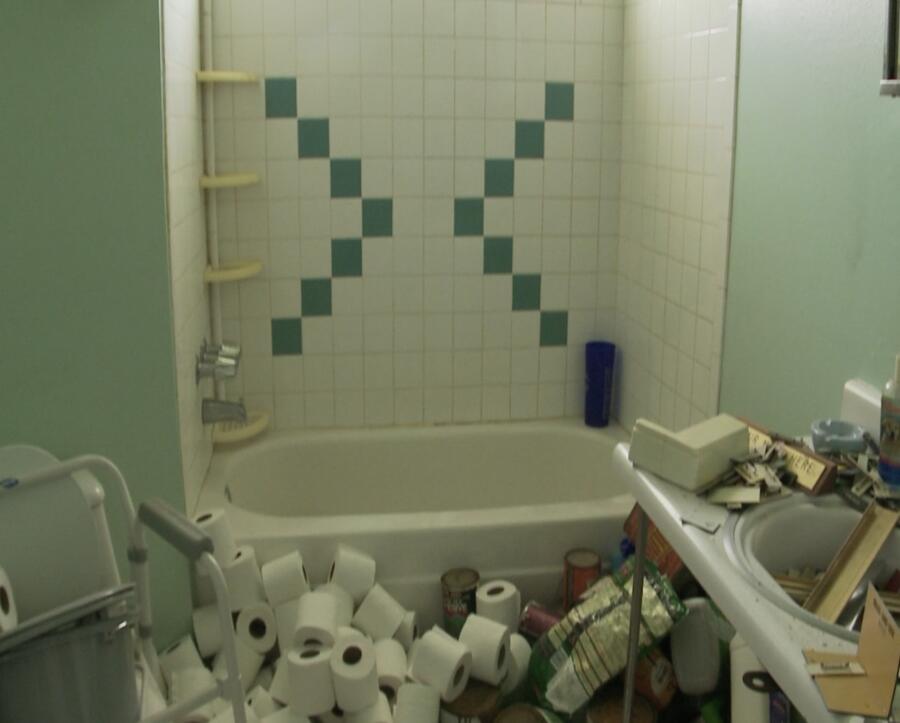 From this messy bathroom and the abundance of toilet paper, it's evident a hoarder once owned this home.