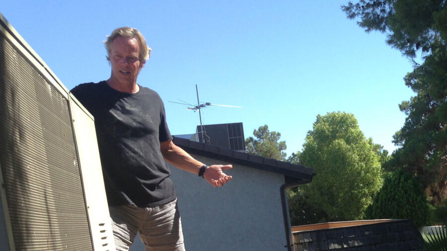 Scott tries to fix the roof-mounted air conditioning unit.
