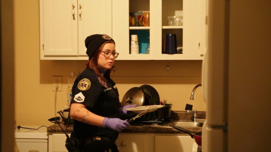 Holly takes food off stove for a patient