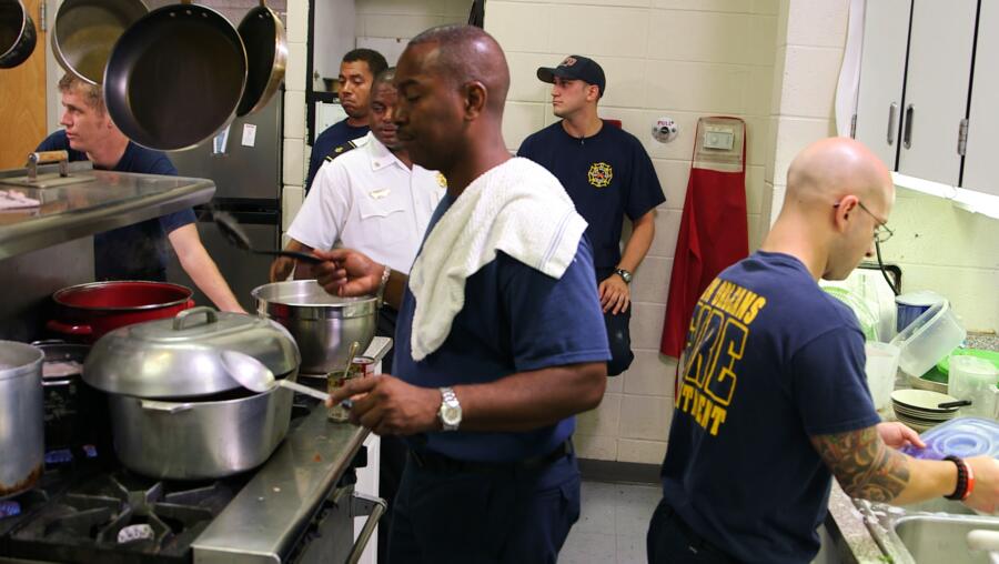 Firefighters make dinner at their firehouse