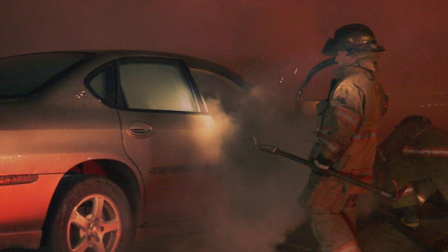 Firefighters put out a car fire