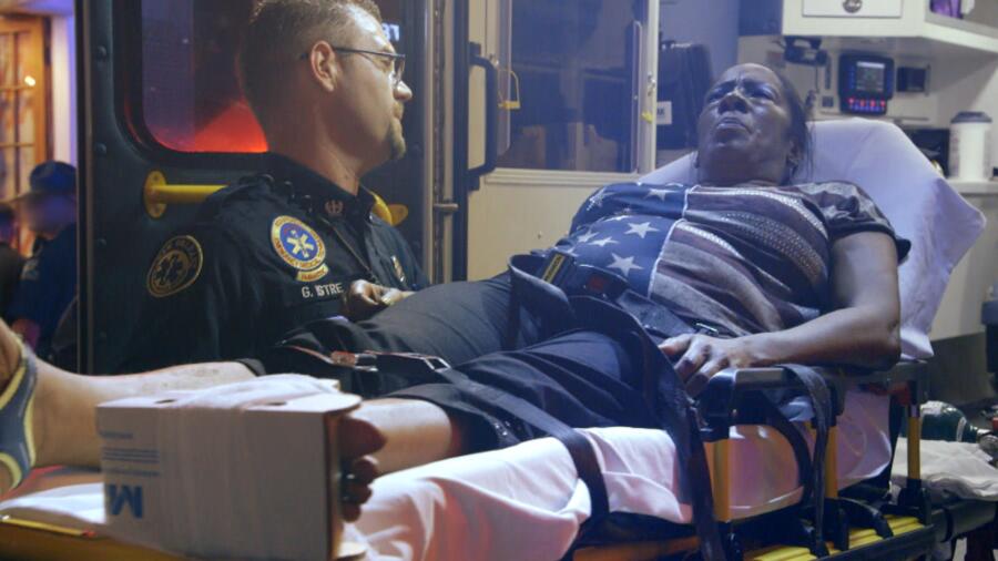 Gavin lifts a patient into the ambulance