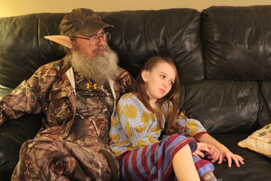 Hey, don't touch the ears! Elf Si relaxes with Jep's daughter Lily while the Robertson women finish cooking dinner.