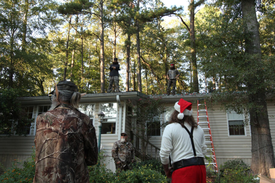 After a long day giving away office supplies to children, Willie and Si arrive at Phil and Kay's house in time to see Jase and the rest of the guys putting up Christmas lights.