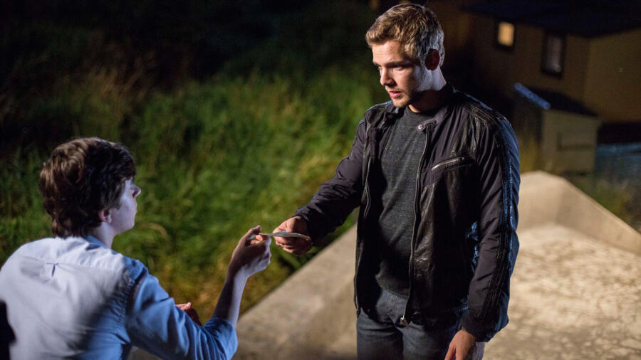 Dylan hands Norman a note
