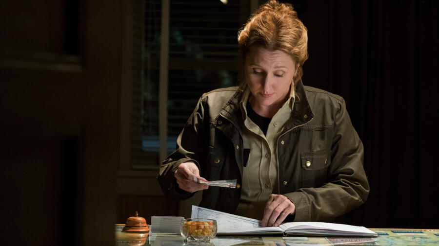 Sheriff Greene looks through the motel registry.