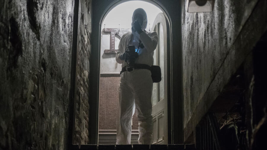 A crime scene investigator documents the Bates' house.