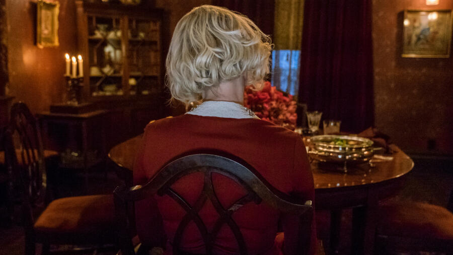 Mother is seated at the table.