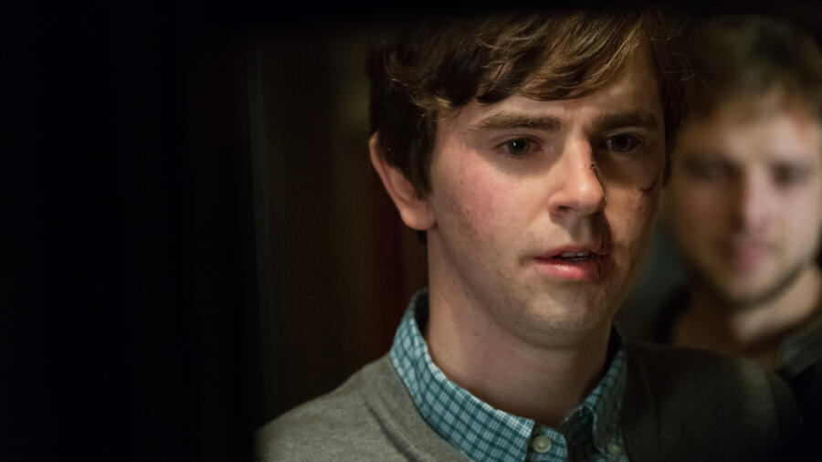 Norman turns to stand at the kitchen sink.