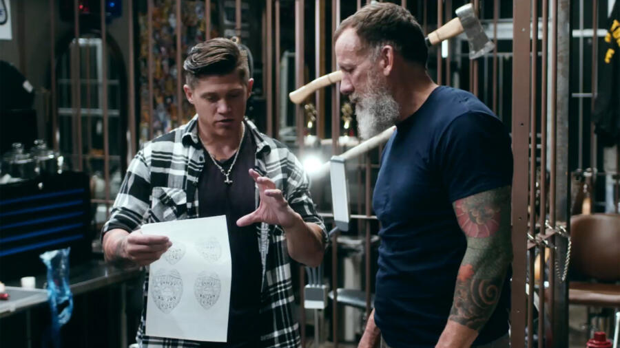 Tony shows client Chuck Bridges the design for his tattoo.