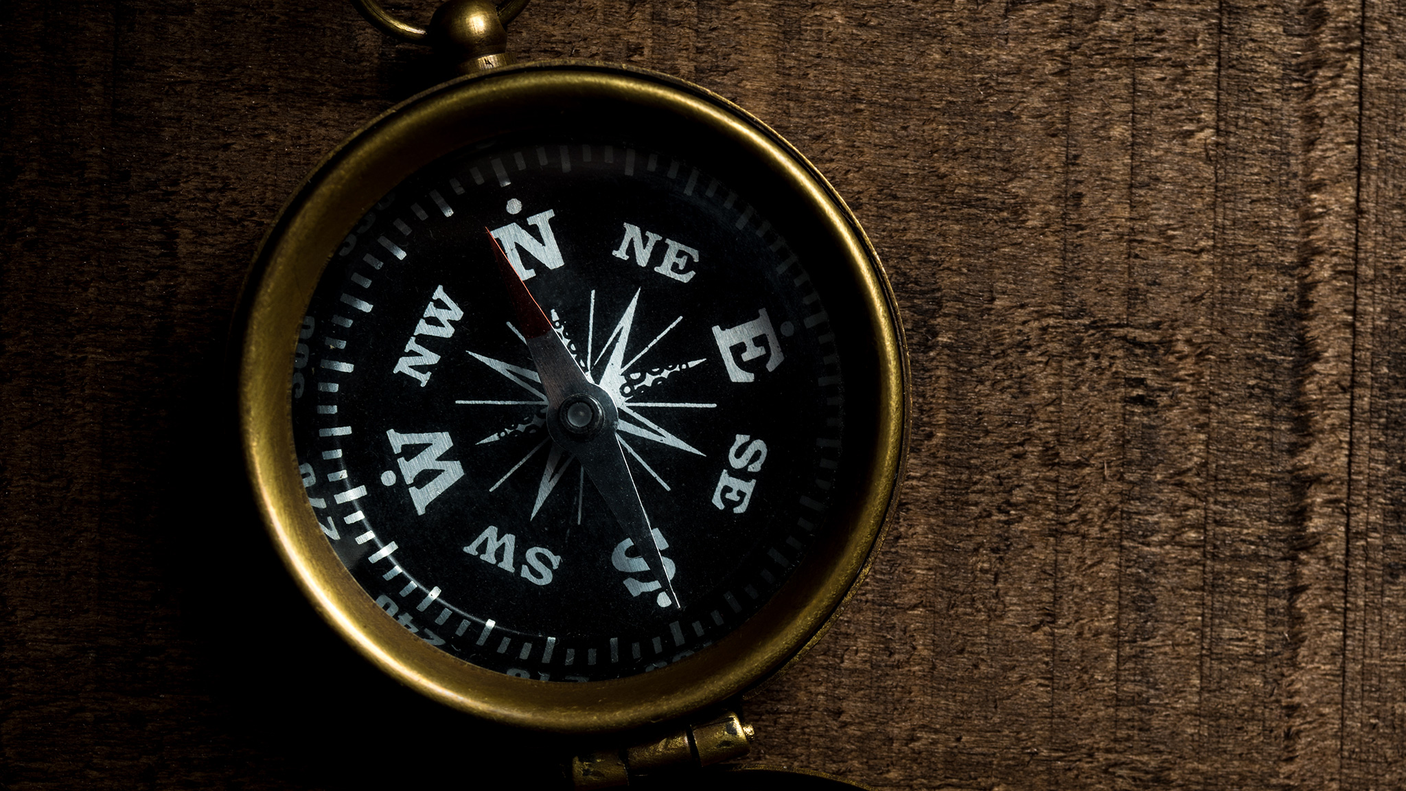 A compass sits on a wooden table