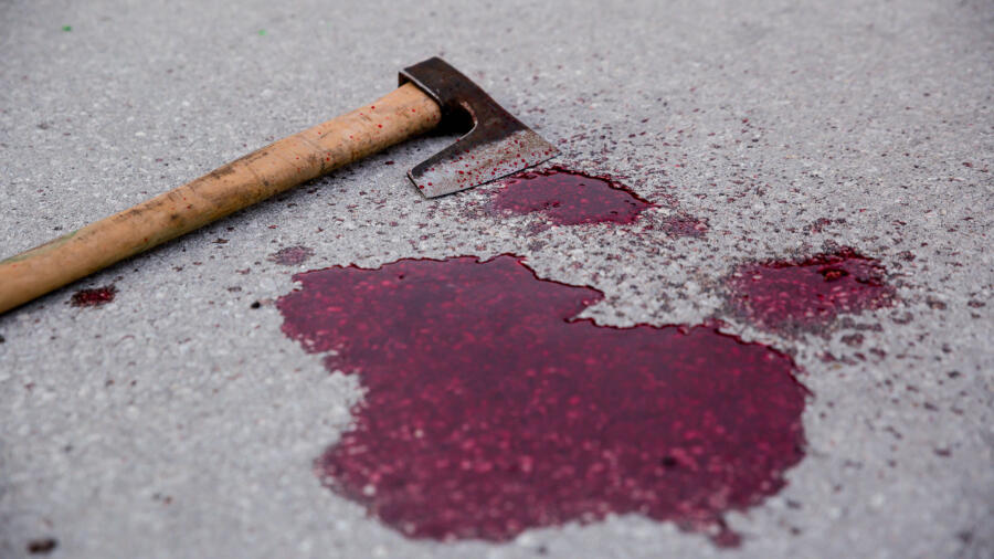 Conceptual photo of a bloody axe on the floor