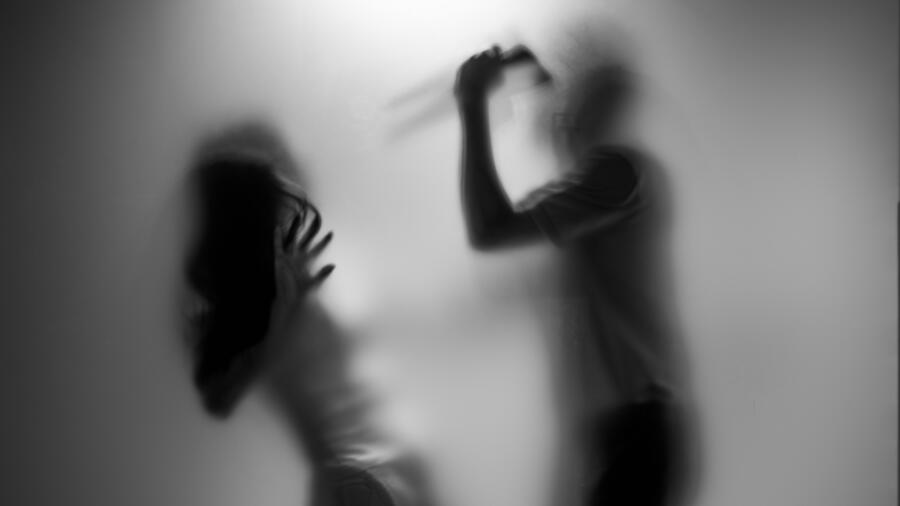 Conceptual photo of a man about to attack a woman with a knife