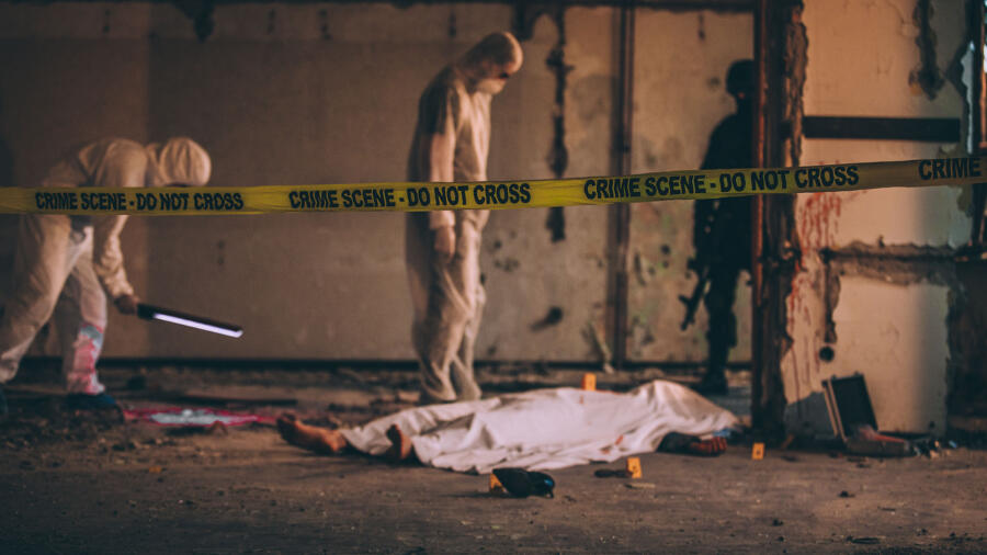 Detectives, police officer and forensics on murder crime scene