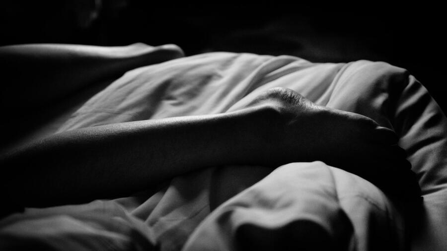 Conceptual image of a dead woman's leg in bed