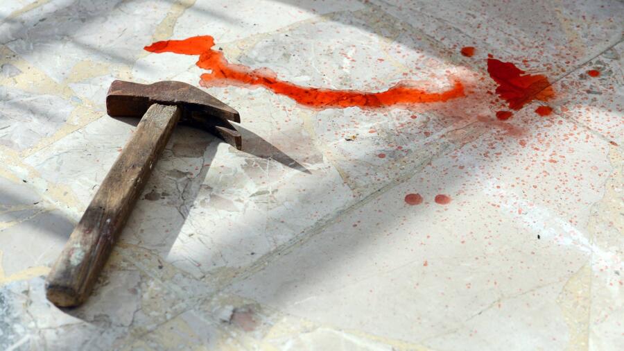 Conceptual photo of a bloody hammer on a floor.