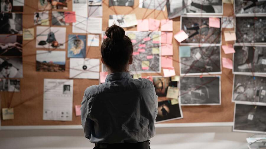 Female detective looking at an investigation board